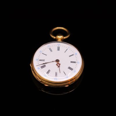 a gold pocket watch with roman numerals on the face