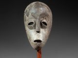 a close up of a mask on a wooden stand