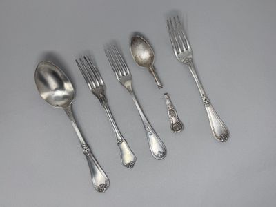 cinq cuillères en argent et six cuillères en argent sur une table
