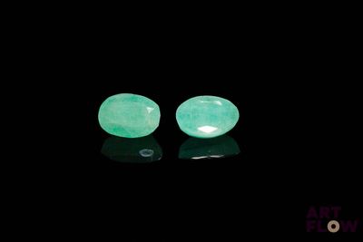 une paire de boucles d'oreilles en jade vert sur un fond noir