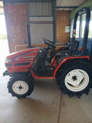 a red tractor that is parked in a garage