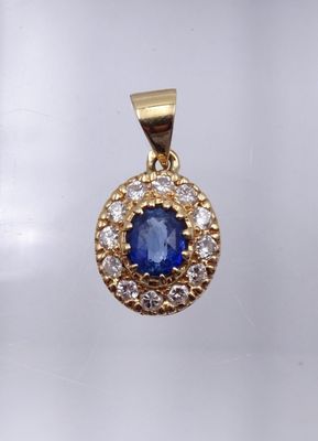 un gros plan d'un pendentif en saphir bleu et diamants sur fond blanc