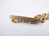a close up of a gold chain bracelet with a name tag on it