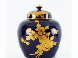 a black vase with gold flowers on it