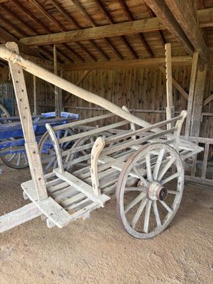 un chariot en bois avec un siège en bois dans une grange