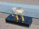 une table basse en verre sur laquelle trône un éléphant doré