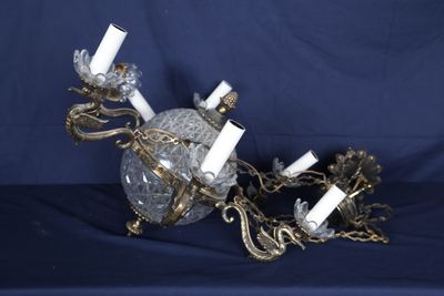 une boule de cristal avec des bougies suspendues à une chaîne, sur fond bleu
