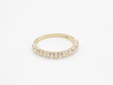 a yellow gold ring with white diamonds on a white background