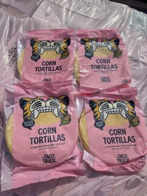 quatre sachets de tortillas de maïs posés sur un sac en plastique