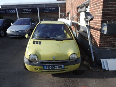 a small yellow car parked in front of a brick building