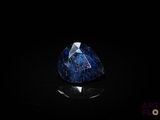 a close up of a blue sapphire stone on a black surface