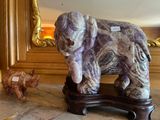 une statue représentant un éléphant et un cochon assis sur une table