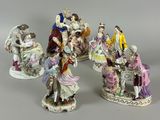 five figurines of people sitting on a bench