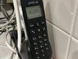 a cell phone that is plugged into the wall next to a charger