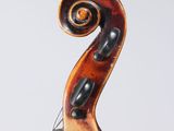 a close up of the back of a violin, with a fiddle in the foreground