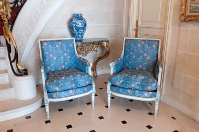 two chairs that are sitting in front of a staircase