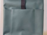 l'arrière d'un sac à dos bleu muni d'une sangle marron