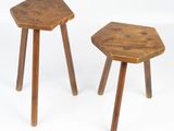 two small wooden stools sitting next to each other on a white surface