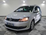 Le fourgon VW blanc est garé sur un sol carrelé à damier.