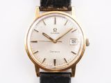 a gold watch with a white dial on a black strap
