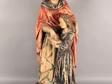 une statue ancienne d'une femme tenant un bébé dans ses bras