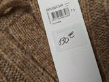 the label on the sweater is attached to the tag
