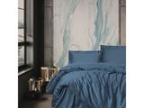 un lit avec une couette bleue et des oreillers dans une chambre