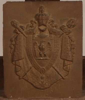 une plaque en pierre sur laquelle figurent des armoiries et une couronne