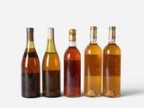 several bottles of wine are lined up on a white surface