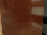 an image of a very old wooden cabinet in the corner of a room