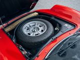 a red sports car with a flat tire in the trunk