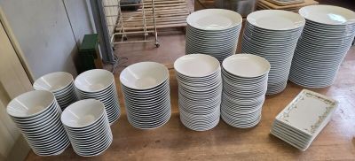 many stacks of plates and cups on the table