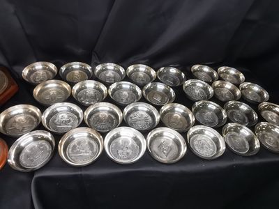 une pile d'assiettes en argent posée sur une nappe noire