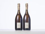 two bottles of wine sitting on top of a table next to each other