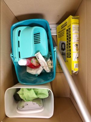 un carton contenant un aspirateur et un carton contenant une boîte de produits d'entretien