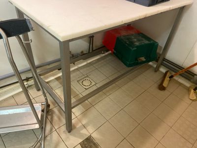 un comptoir blanc avec un tabouret et une boîte verte posée dessus
