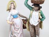 une figurine représentant un homme et une femme portant des paniers sur la tête