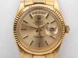 an image of a gold rolex watch on a white surface