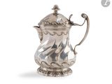 une cafetière ancienne en argent avec une anse, sur fond blanc