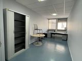 une pièce contenant un bureau, des étagères et une chaise