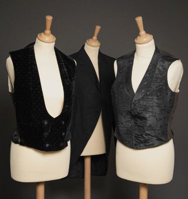 deux mannequins vêtus de gilets noirs, exposés sur un fond gris