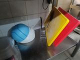 a yellow and red cutting board sitting on a metal table