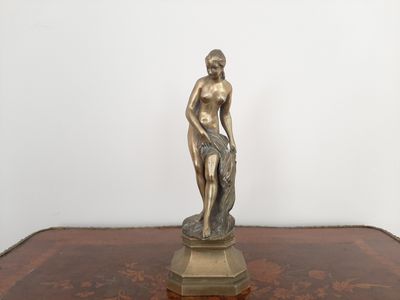 une statue représentant un homme assis sur une table en bois