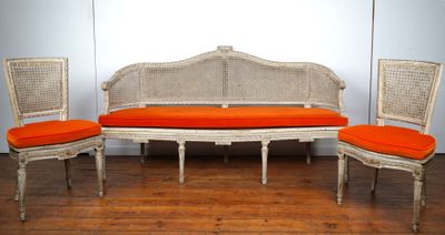 trois chaises et un banc dans une pièce avec du parquet