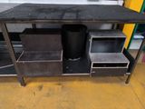 an image of a metal work table with a trash can