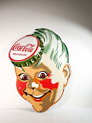 Grande plaque émaillée Coca-Cola à décor d'un visage
