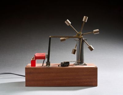 une petite maquette d'éolienne posée sur un socle en bois