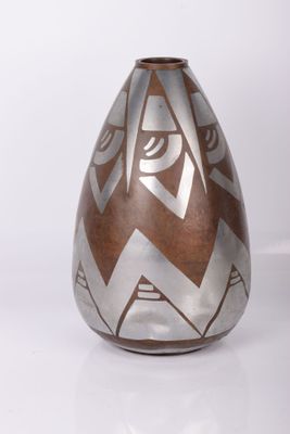 un vase brun et blanc posé sur une surface blanche