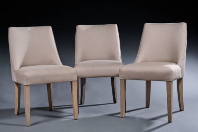 trois chaises beiges placées les unes à côté des autres dans une pièce sombre