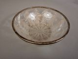 a clear glass bowl with a gold rim on a table